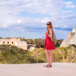 solo female traveler looks out at uxmal maya ruins in mexico