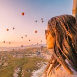 Goreme Cappadocia Turkey hot air balloons during Sunrise over the fairytale landscape hills of Kapadokya, young woman in hot air balloon