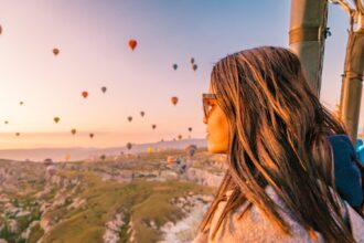 Goreme Cappadocia Turkey hot air balloons during Sunrise over the fairytale landscape hills of Kapadokya, young woman in hot air balloon