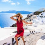 Travel Tourist Happy Woman Running Stairs Santorini, Greek Islands, Greece, Europe. Girl on summer vacation visiting famous tourist destination having fun smiling in Oia
