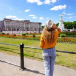young traveler looks at buckingham palace in london on a sunny day
