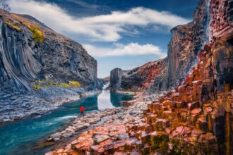 traveler standing by a river in the beautiful Studlagil Canyon in iceland