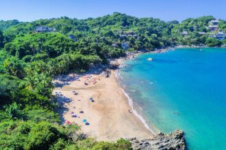 Panoramic aerial view of the beautiful beaches of Sayulita surrounded by greenery on a sunny day