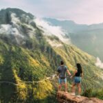 young traveler couple looking at misty mountains in sri lanka during sunrise