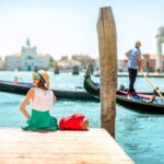Female traveler sitting on a pier in Venice