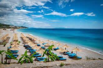 Beach chairs facing blue waters of Dhermi beach