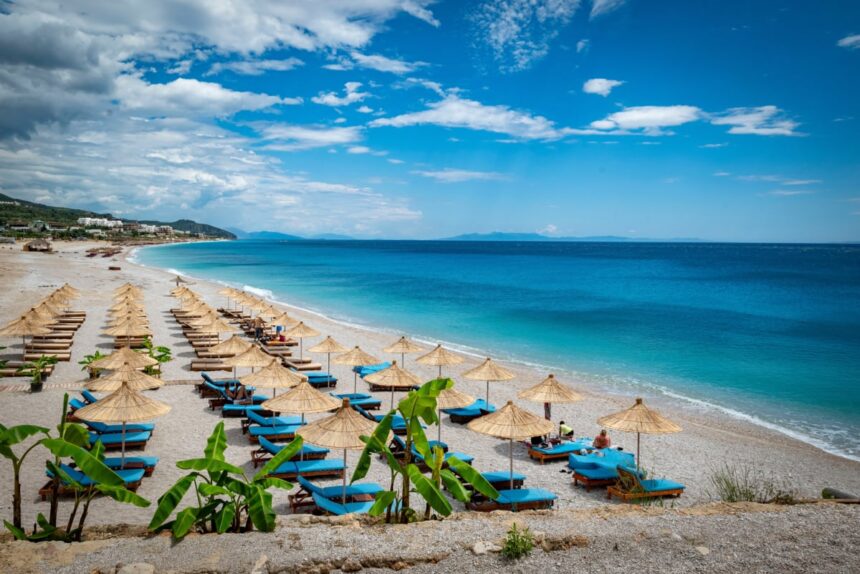 Beach chairs facing blue waters of Dhermi beach