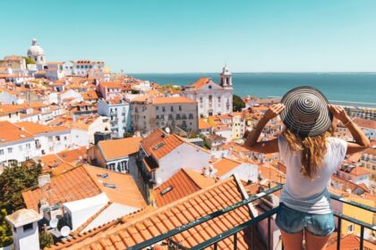 Young Woman Admiring A View Of Alfama In Lisbon, Portugal, Southern Europe