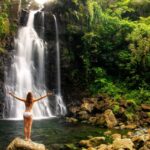 Female tourist visiting majestic waterfall in Fiji