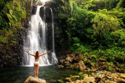 Female tourist visiting majestic waterfall in Fiji