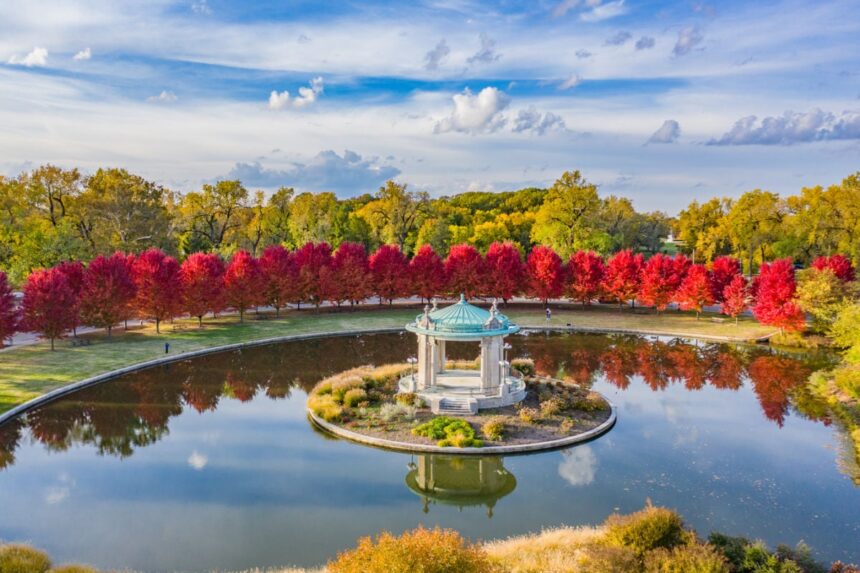 Red foliage lining reflective pond in Forest Park of St. Louis