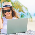 Digital nomad working on palm tree-lined beach in Caribbean