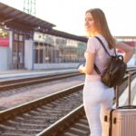 Young woman with luggage awaiting train