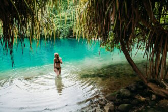 Female tourist in blue water lagoon of Portland, Jamaica