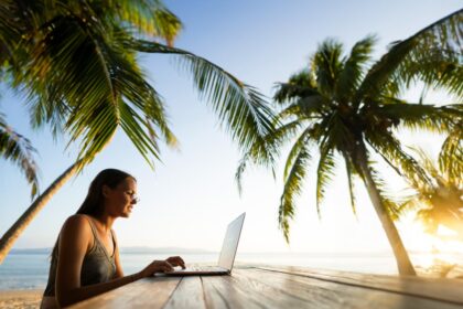 Digital nomad working outdoors under palm trees