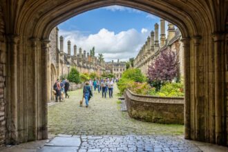 People walking down historic street in Wells, UK