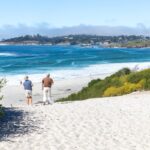 Couple walking on white sand beach in Carmel, CA
