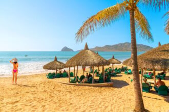Vacationers relaxing under beach huts in Maztalan, Mexico