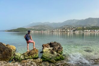 Woman overlooking clear waters of Himare, Albania