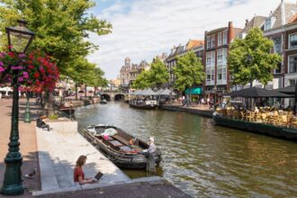 Woman on laptop near canal in Netherlands