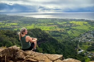 Liz Fox sitting at the top of the Sleeping Giant in Kauai, Hawaii