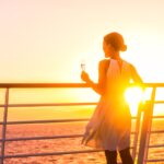 Cruise passenger with wine glass at sunset