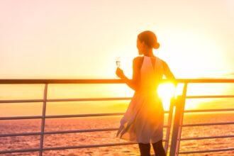 Cruise passenger with wine glass at sunset