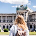 Woman looking to Hofburg complex in Vienna. Female tourist traveling in Austria