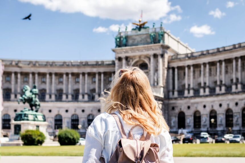 Woman looking to Hofburg complex in Vienna. Female tourist traveling in Austria