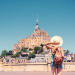 Rear view of woman looking at Le Mont Saint Michel- Normandie in France