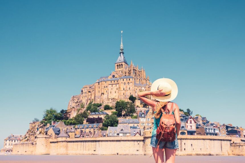Rear view of woman looking at Le Mont Saint Michel- Normandie in France