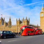 Double-decker buses and black cab on Westminster bridge with Big Ben and Houses of Parliament at background, London, UK
