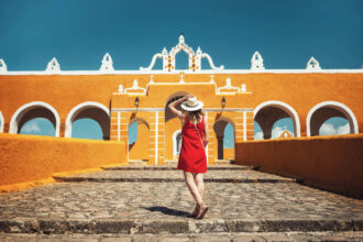 Young Woman Admiring The Colonial Architecture Of Izamal, Mexico