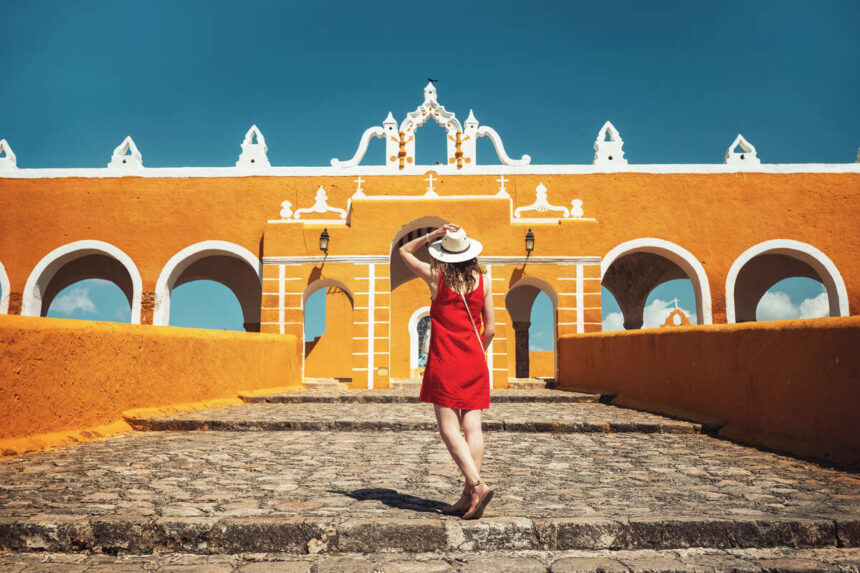 Young Woman Admiring The Colonial Architecture Of Izamal, Mexico
