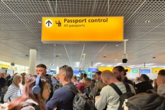 Amsterdam, Netherlands - Passengers waiting in line to clear passport control at Amsterdam Schiphol Airport.
