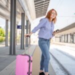 Woman with pink luggage waiting for train