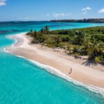 Lone beachgoer walking along shoreline in Anguilla