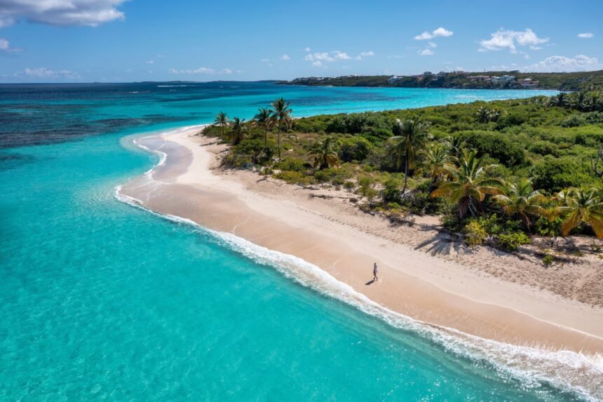 Lone beachgoer walking along shoreline in Anguilla
