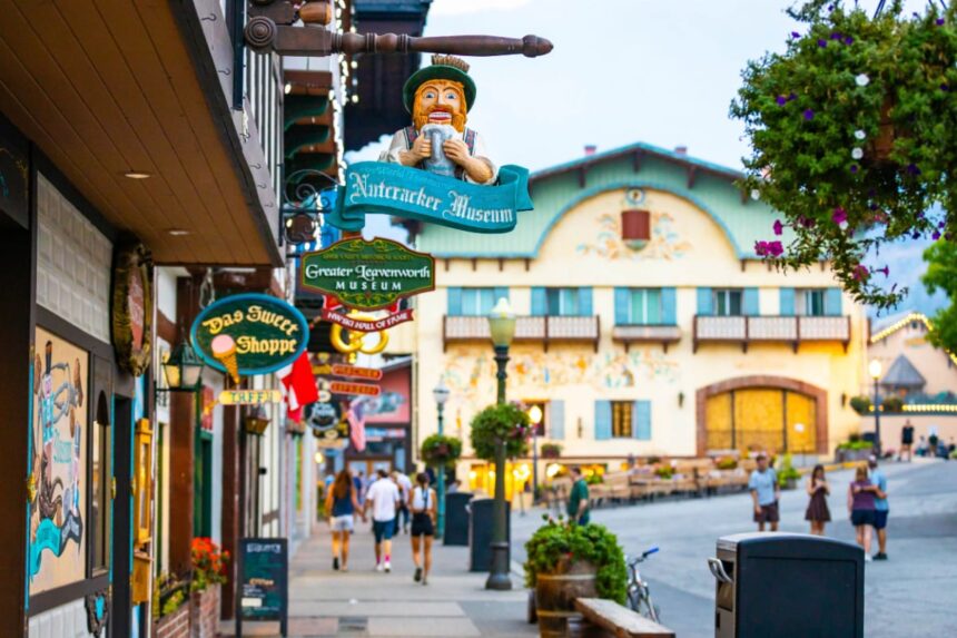 People enjoy a warm summer evening on the street in Leavenworth city center among Bavarian-style buildings and businesses