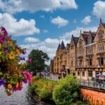 Victorian-era buildings line a busy street in Inverness, Scotland during summer