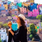 Colorful houses in Guanajuato, Mexico with woman drinking from a mug