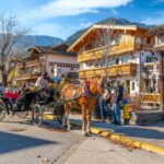 A horse carriage for hire with tourists in the colorful Bavarian themed village of Leavenworth.