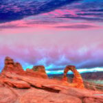 Red rock formations under cotton candy skies in Arches National Park