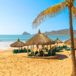 Tourists enjoy a private resort club with straw hut cabanas along the sandy Playa Gaviotas beach in the Golden Zone of Mazatlan, Mexico, along the Sinaloa Riviera.