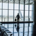 One man standing at the airport gate waiting his flight with delay or canceled