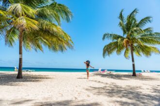 woman on beach in Barbados island. Caribbean holidays. Dover beach, travel destination. Girl walking with sun hat