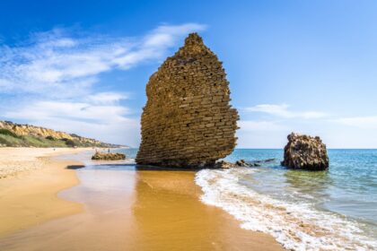 Wall of ruins on beach in Mazagon, Spain