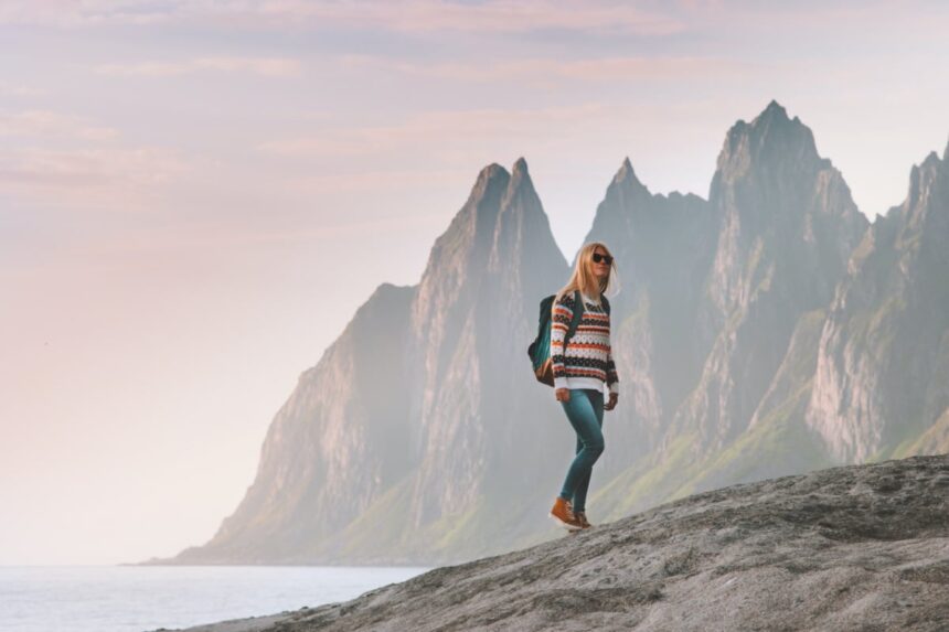 Tourist woman traveling in Norway active lifestyle vacations outdoor Okshornan peaks landscape Senja island