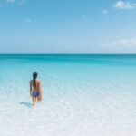 Woman stepping into ocean in South Caicos, Turks and Caicos