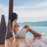 Woman on a bikini sitting in a bikini admiring the view of Coatepeque Lake in El Salvador